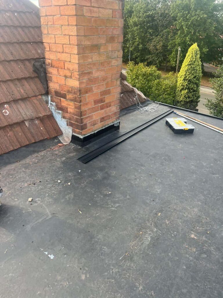 This is a photo of a flat roof which has just been repaired, there is also a chimney stack and some leadwork has also been dressed. Works carried out by MCM Roofing Repairs Sturminster Newton